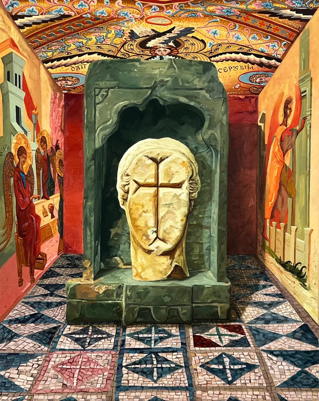 Una cabeza de piedra sin rostro, con una cruz tallada donde estarían los rasgos, ocupa un nicho verde en una capilla bizantina de techo dorado, con ángeles pintados en los muros y un suelo de mosaico geométrico.