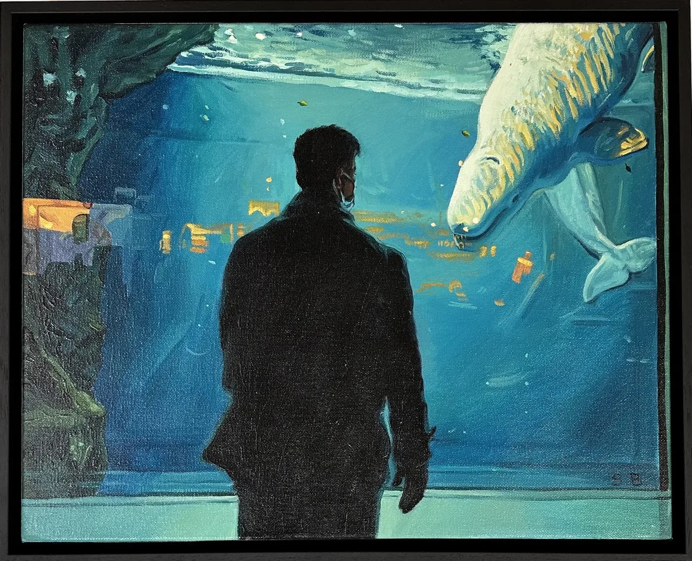 Silueta de un hombre frente al cristal de un acuario donde pasa una beluga.